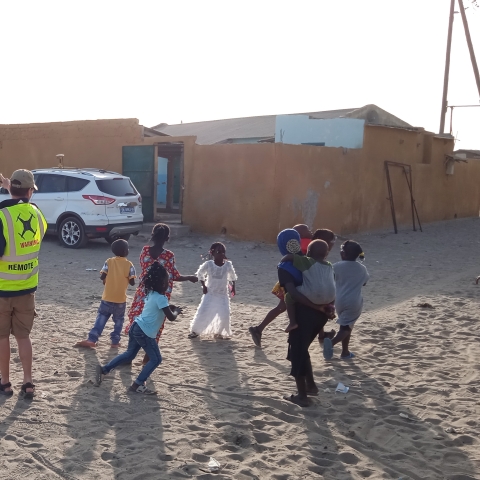 Toby Meredith with a group of children chasing a drone
