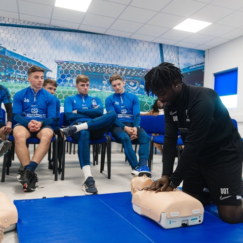 Students practice CPR techniques on a dummy