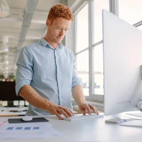 A man working at a desk with a screen
