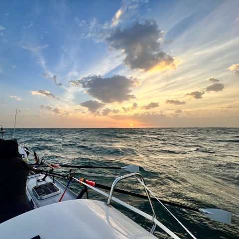Rowing boat on an ocean against a beautiful sky 