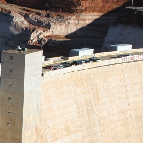 Dam holding back water, with natural landscape behind.