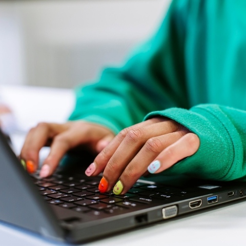 Hands typing on laptop