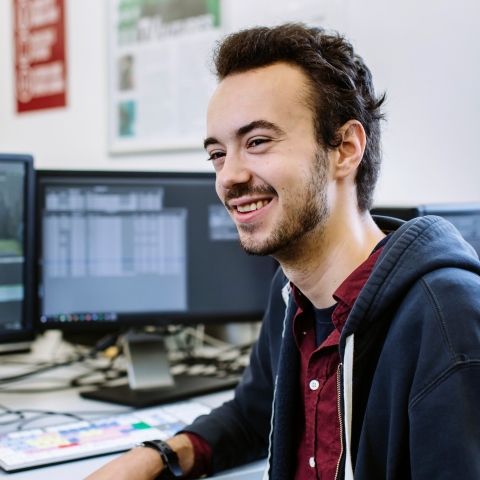 Smiling male student at computer