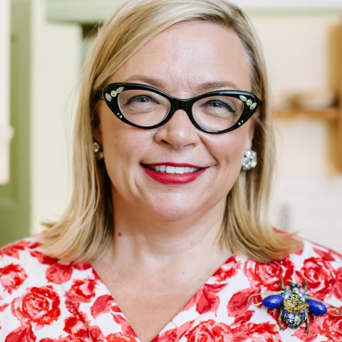 photo of a smiling Deborah Sugg Ryan in a lovely red dress