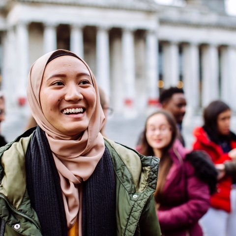 International students smiling and laughing outside Portsmouth Guildhall