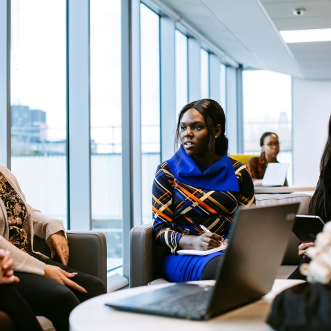 Group of people sitting at a desk with law documents and wig