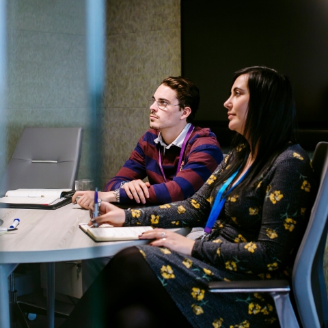 Female and male employee attending an at-work seminar
