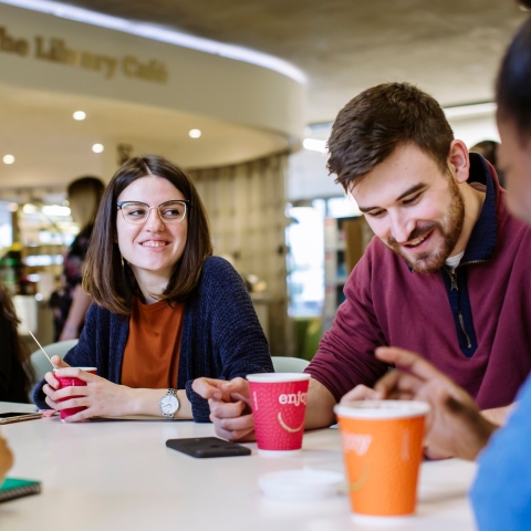 Male and female students in the library cafe