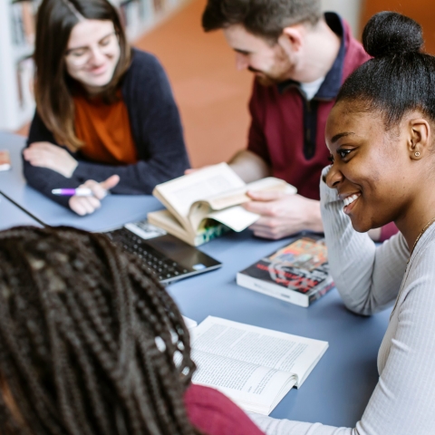 Students in library smiling in group study