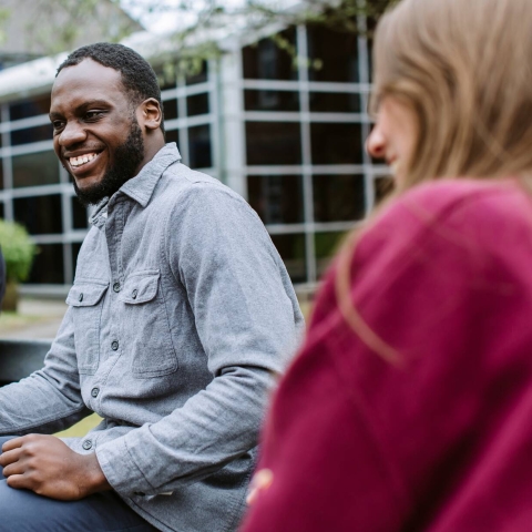 A student chatting with friends on a bench