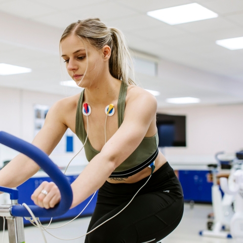 Person on an exercise bike monitored by an ECG