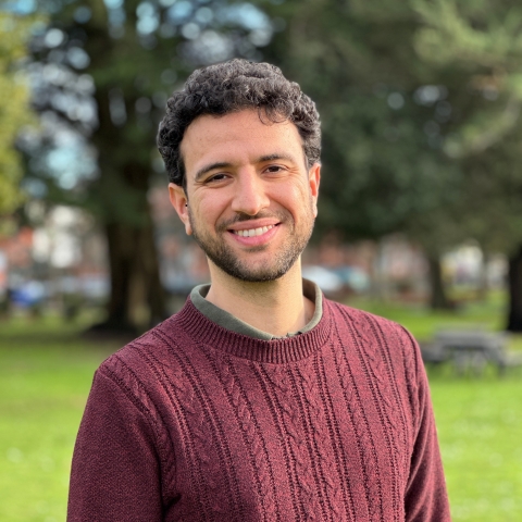 Global Recruitment officer Guiliano looking at the camera with trees in the background