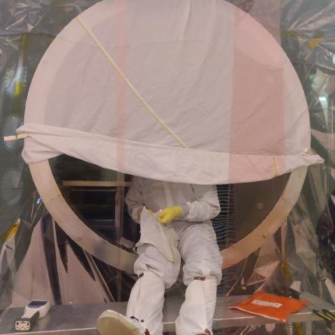 scientist inside a circular cavity dressed in hazmat suit