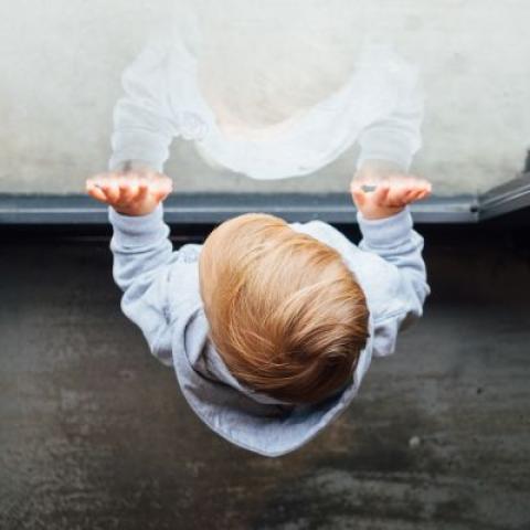 Overhead view of young boy standing in front of window
