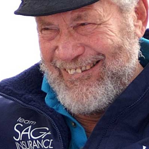 Sir Robin Knox-Johnston smiling to camera wearing cap
