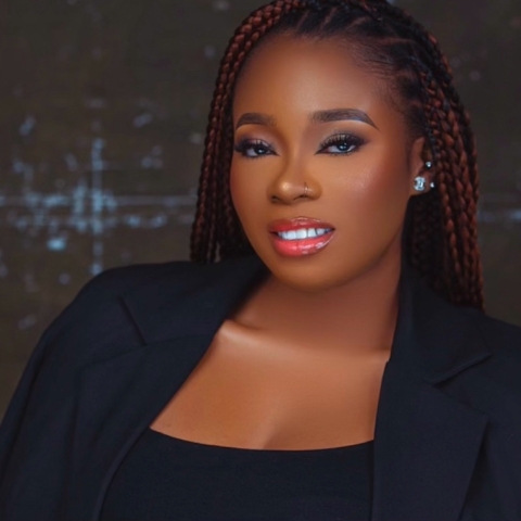 Jenny smiling at the camera wearing a blazer