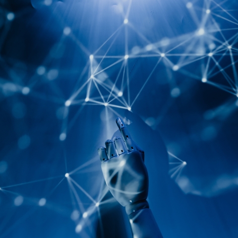 A robot hand holding a network-connected device.