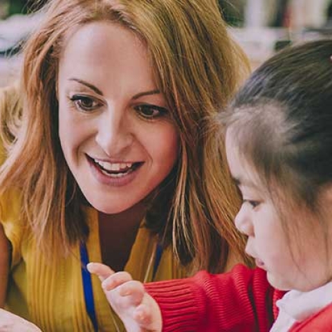 Smiling primary school teacher with a pupil