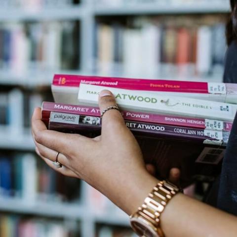 student carrying stack of books