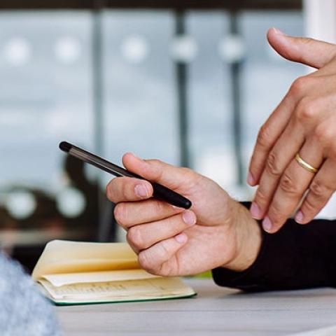 student making notes in a notepad during a meeting