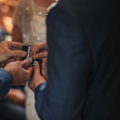 Picture of two men exchanging rings at their wedding.