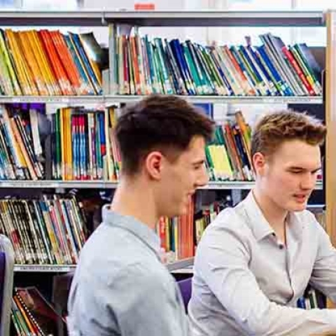 Three students studying in the library