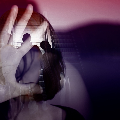 Person with hand on glass and silhouettes of people obscuring face