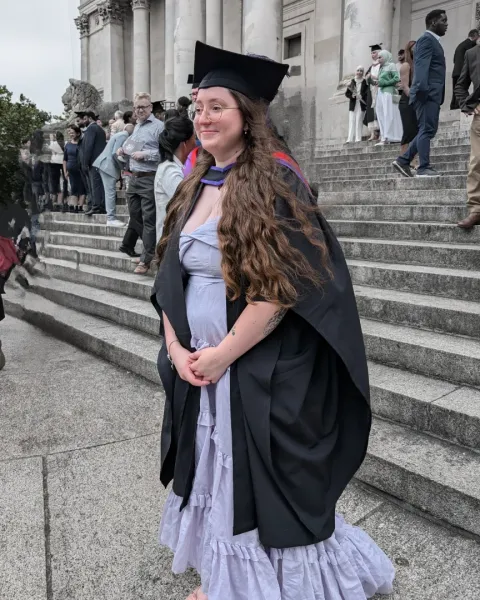 Student wearing graduation cap and gown.
