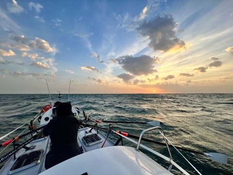 Rowing boat on an ocean against a beautiful sky 