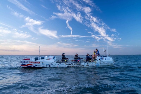 Six rowers rowing on the ocean