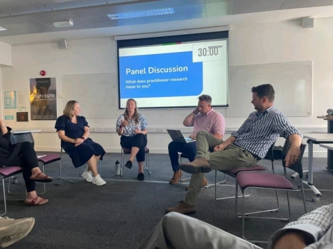 A group of people seated in chairs, attentively watching a presentation on a large screen in front of them.