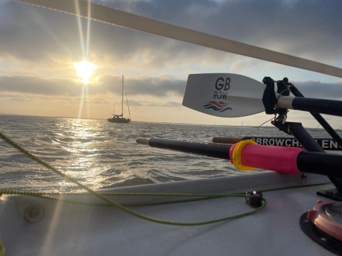 A sunset at sea with a GB Row Challenge oar in the foreground