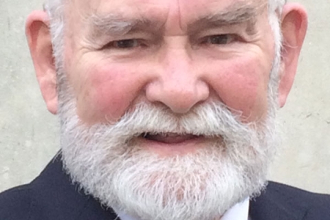 Graham Smart wearing suit and tie and smiling to camera