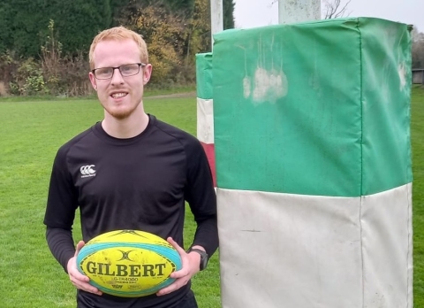 Andrew Fleet posing with a rugby ball