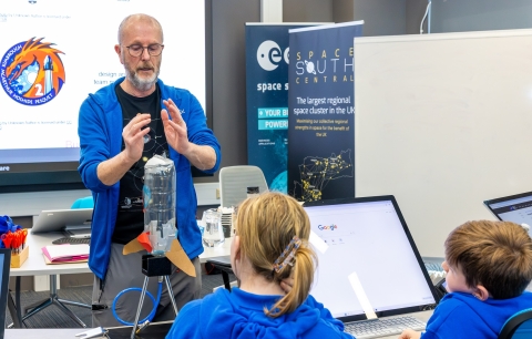 Jeremy Thomas in a teaching room, facing pupils from Miltoncross Academy during a workshop to design and build a water projected rocket