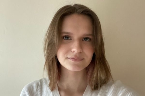 Katarzyna, a young female wearing white jumper with brown should length hair