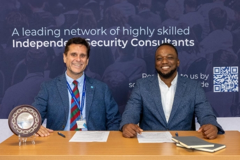 Dennis Roe and Dr John Akerele sat at desk with papers