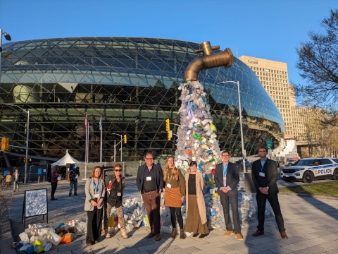 Revolution Plastics Institute team beside the plastic tap sculpture at INC-4 in Ottawa