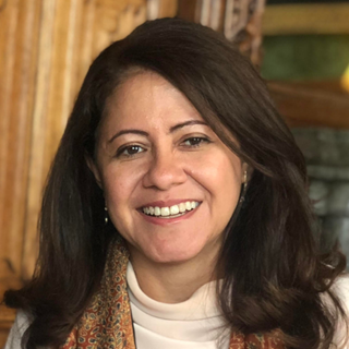 A woman with brown shoulder-length hair, smiling