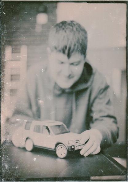 black and white old fashioned style photo of student with toy car