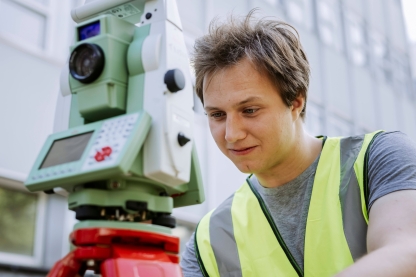 Student conducts measurements using landscape mapping device outside Technology Facilities