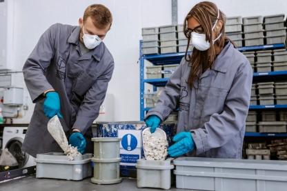 Students in overalls measuring out raw ingredients at Technology Facilities