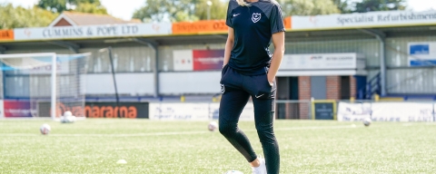 Woman standing on football pitch