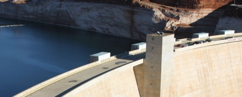 Dam holding back water, with natural landscape behind.