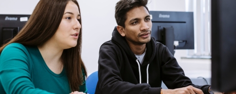 two students looking at a computer screen