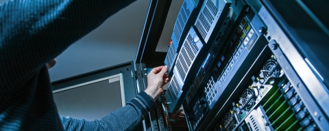 Information systems student reaches into server