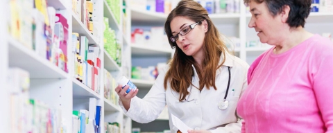 A pharmacist advising a female patient on medicine in a pharmacy