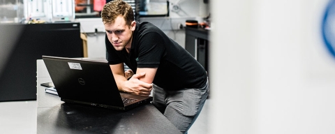Engineering and management student uses laptop at work