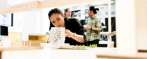 Female student holding architecture model