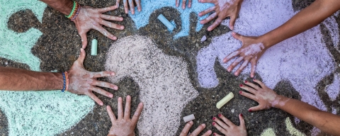 Hands on pavement graffitied with chalk 